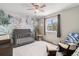 Charming Bedroom with jungle-themed wallpaper, a crib, and a glider at 709 Arrow Ct, Lafayette, CO 80026