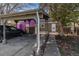Charming home exterior with carport, sidewalk, and freshly painted purple accent house in the background at 709 Arrow Ct, Lafayette, CO 80026