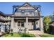 Two-story home featuring a front porch, black pergola, and gray siding at 544 N Logan St, Denver, CO 80203