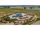 Aerial view of community pool with hot tub, clubhouse, and lake in the background at 1876 Chaffee Crest Dr, Berthoud, CO 80513