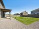 Landscaped backyard featuring a gravel area, grassy lawn, covered patio, and full fencing for a private outdoor space at 1876 Chaffee Crest Dr, Berthoud, CO 80513