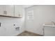 Functional laundry room with white cabinets, sink, and neutral flooring at 1876 Chaffee Crest Dr, Berthoud, CO 80513