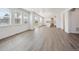 Open floor plan living room with wood floors and natural light from the many windows and sliding glass door at 1876 Chaffee Crest Dr, Berthoud, CO 80513