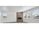 Living room with wood floors, stone fireplace, white trim, and natural light from the many windows at 1876 Chaffee Crest Dr, Berthoud, CO 80513
