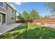 Spacious backyard with green lawn, a concrete patio, landscaped area, and fenced perimeter at 418 Hayloft Way, Brighton, CO 80601