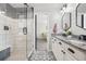 Open bathroom view of a tiled shower and vanity; with view of the bedroom at 418 Hayloft Way, Brighton, CO 80601