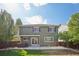 Rear exterior view of the home with a patio, hot tub, manicured lawn and fenced yard at 418 Hayloft Way, Brighton, CO 80601