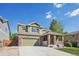 Two-story home with a brick and siding exterior, complemented by a well-manicured lawn and a concrete driveway at 418 Hayloft Way, Brighton, CO 80601