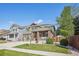 A two-story home with a brick-accented facade and a well-maintained lawn, set under a clear blue sky at 418 Hayloft Way, Brighton, CO 80601