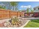 Landscaped backyard with a stone boulder and firepit area for outdoor enjoyment at 418 Hayloft Way, Brighton, CO 80601