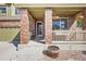 Charming front porch with brick columns, hanging planters, and a cozy entrance, inviting guests at 418 Hayloft Way, Brighton, CO 80601