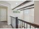 Hallway featuring wooden beams, an iron railing, and views of the lower level and natural light at 418 Hayloft Way, Brighton, CO 80601