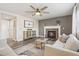 Bright living room with a fireplace, neutral tones, stylish decor, and a view of the open layout at 418 Hayloft Way, Brighton, CO 80601