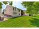Expansive backyard with lush green lawn, mature trees, and a deck for outdoor entertaining at 160 Las Lunas St, Castle Rock, CO 80104