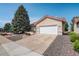 Exterior view of house with a large evergreen tree and a long concrete driveway leading to the attached garage at 160 Las Lunas St, Castle Rock, CO 80104