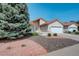 Inviting home with a terracotta roof, two-car garage, and beautiful landscaping and rock features at 160 Las Lunas St, Castle Rock, CO 80104