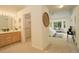 Bright main bedroom featuring an ensuite bathroom, walk in closet, and sunlit bay window with sitting area at 160 Las Lunas St, Castle Rock, CO 80104