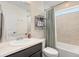 Bright bathroom with shower-tub combination and storage shelving at 239 S Old Hammer St, Aurora, CO 80018