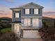 Charming two-story home with a private balcony above the garage and beautiful blue horizontal siding at sunset at 239 S Old Hammer St, Aurora, CO 80018