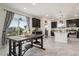 Bright kitchen with dark cabinets, granite countertops, island, and a large window overlooking the yard at 239 S Old Hammer St, Aurora, CO 80018