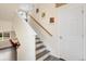 Bright entryway featuring a staircase with wooden handrail and a view of an adjacent office space at 239 S Old Hammer St, Aurora, CO 80018