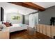 A sunlit main bedroom featuring a barn door to the ensuite and hardwood floors at 505 Detroit St, Denver, CO 80206