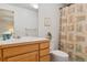 Bathroom with wooden vanity, a white sink, and a toilet with a patterned shower curtain at 7134 W Belmont Dr, Littleton, CO 80123