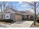 Charming stone and siding home with an attached two-car garage and well-maintained front yard at 7134 W Belmont Dr, Littleton, CO 80123