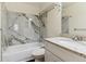 Updated bathroom with a shower-tub, marble-style tiling, and a sleek white vanity with ample storage at 9427 W 89Th Cir, Broomfield, CO 80021