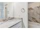 Renovated bathroom with marble surround and white vanity at 9427 W 89Th Cir, Broomfield, CO 80021