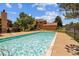 Community pool with refreshing blue water, surrounded by a secure wrought iron fence and mature shade trees at 9427 W 89Th Cir, Broomfield, CO 80021