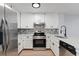 Updated kitchen with white cabinets, geometric backsplash and stainless steel appliances at 12525 E Tennessee Cir # E, Aurora, CO 80012