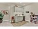 Cozy bar area features sleek gray cabinetry, counter, and wine fridge adjacent to a bookcase with carpet and wood floors at 1982 Peralta Loop, Castle Rock, CO 80104