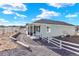 Inviting single-story home with a covered porch, surrounded by decorative gravel, a white fence, and beautiful landscaping at 1982 Peralta Loop, Castle Rock, CO 80104