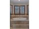 Relax in this soaking tub with tiled surround and plantation shutters for privacy at 5 Tamarade Dr, Littleton, CO 80127
