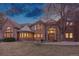 Stately brick home featuring a turret, well-manicured lawn, and mature trees creating a welcoming curb appeal at 5 Tamarade Dr, Littleton, CO 80127