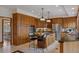 Traditional kitchen featuring oak cabinets, granite counters, stainless steel appliances, and a central island with seating at 5 Tamarade Dr, Littleton, CO 80127