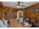Wood-paneled office with built-in bookshelves, a large desk, and comfortable seating creating a professional workspace at 5 Tamarade Dr, Littleton, CO 80127