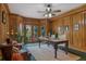 Wood-paneled office featuring a large desk, comfortable seating, and French doors opening to the outdoors at 5 Tamarade Dr, Littleton, CO 80127
