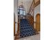 Elegant staircase with blue patterned carpet, wooden banister, a window seat, and natural light at 5 Tamarade Dr, Littleton, CO 80127