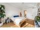 Bright bedroom with hardwood floors, a platform bed, and a glimpse into the ensuite bathroom at 2589 Arapahoe St, Denver, CO 80205