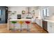 Modern white kitchen with stainless steel appliances, waterfall island, and hardwood floors at 2589 Arapahoe St, Denver, CO 80205