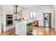 Modern white kitchen with stainless steel appliances, waterfall island, and hardwood floors at 2589 Arapahoe St, Denver, CO 80205