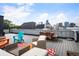 Relaxing rooftop deck area featuring modern outdoor furniture and a stunning city skyline view at 2589 Arapahoe St, Denver, CO 80205