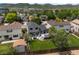 Aerial view of a home with a deck, patio, landscaped lawn, and mature trees in a residential neighborhood at 5750 S Youngfield St, Littleton, CO 80127