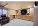 Finished basement area features built-in cabinetry, a counter top, mini fridge, and a mounted television at 5750 S Youngfield St, Littleton, CO 80127