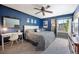 Comfortable bedroom featuring stylish blue walls, a cozy bed, and a dedicated workspace with a desk and chair at 5750 S Youngfield St, Littleton, CO 80127