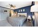 Bedroom with blue accent wall, king bed, and dedicated desk space; also features a walk-in closet for storage at 5750 S Youngfield St, Littleton, CO 80127