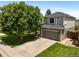 Exterior elevation of gray, two-story house with a well-kept lawn and two car garage at 5750 S Youngfield St, Littleton, CO 80127