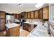 Updated kitchen featuring stainless steel appliances, wood cabinetry, and a central island with white countertops at 5750 S Youngfield St, Littleton, CO 80127